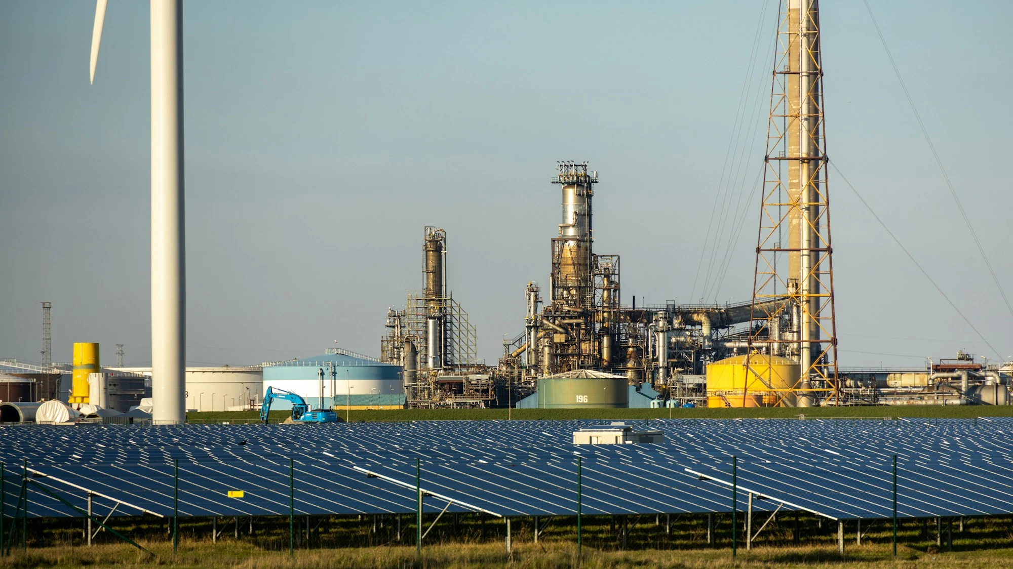 Industrial energy infrastructure with solar panels and a wind turbine